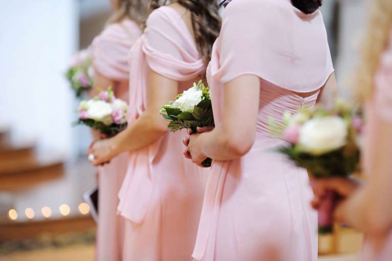 Bridesmaids in a line with their flowers