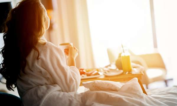 woman in bed eating breakfast