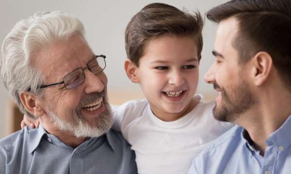 Grandfather, son and grandson smiling at eachother