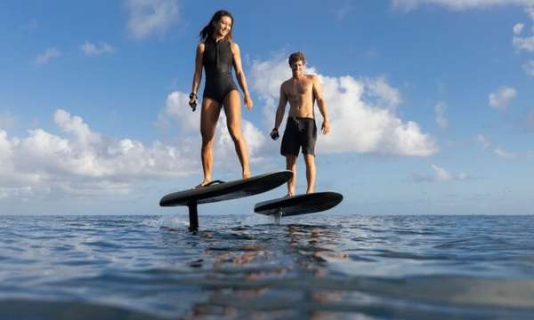 2 people standing on a foil board in the sea