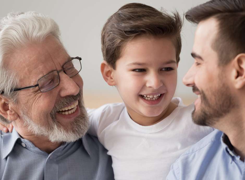 Grandfather, son and grandson smiling at eachother